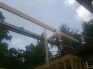 Carpenter setting a ridge beam over a new addition frame — Ice Dam Removal by Roofing Brothers in Quarryville