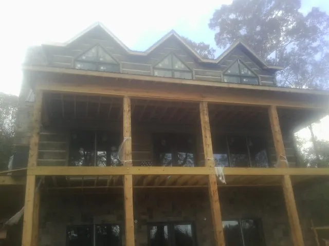 Dormers and porch framing on a large log home under construction — Roof Coating work by our crew in Quarryville